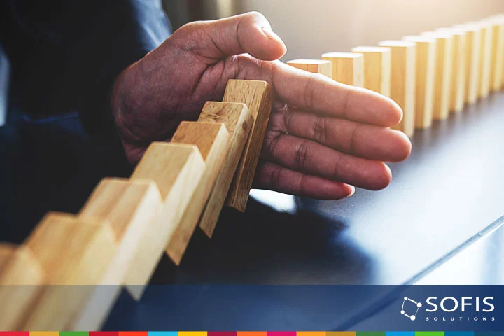 Mano frenando la caída de bloques de madera